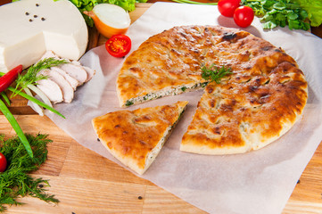 Selective Focus Traditional meat closed pie on the table. Composition of ingridients.