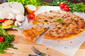 Selective focus vegetarian closed pie on the table. Composition of ingridients.