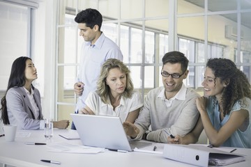 Obraz premium Casual business team having a meeting using laptop