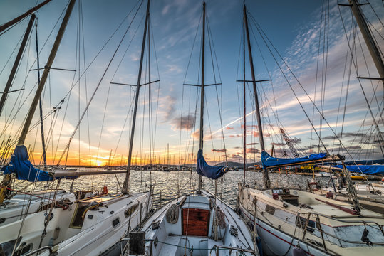 Boats in Alghero harbor at sunset