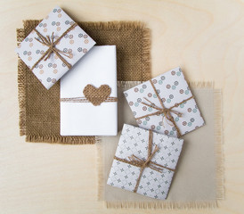 Rustic handmade gift boxes over wooden background. Top view, flat lay