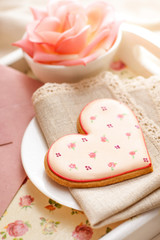 Romantic breakfast in bed. Breakfast tray with heart shaped biscuit, sparkling drink, rose and envelope.