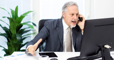 Portrait of an angry businessman yelling at phone