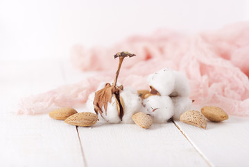 almonds and cotton with rose textile on whte wooden table. selec
