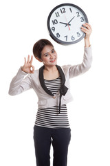 Young Asian business woman show OK with a clock.