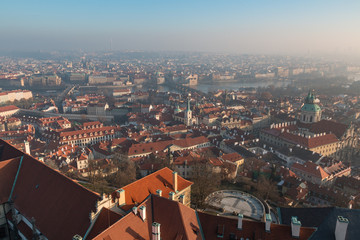 Fototapeta na wymiar The red roof in Prague. Panoramic view of Prague in winter day with dense fog in the city.