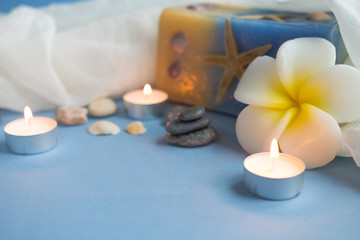 Fototapeta na wymiar Seashells and a candle on a light background in marine style
