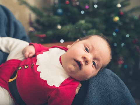 Baby wearing santa outfit at christmas