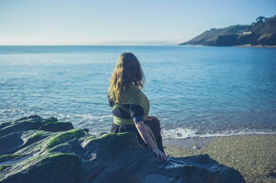 Woman sitting on rocks by water