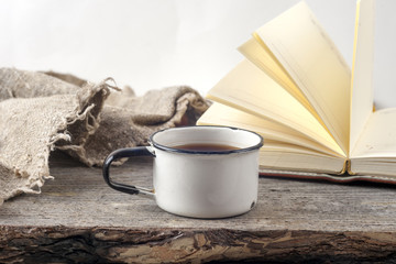Old vintage books, cup of tea, cake and keys on rustic wooden table