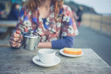 Woman pouring tea outside