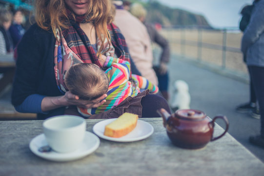 Mother breastfeeding baby in cafe outside