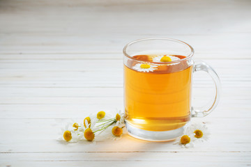 cup of chamomile tea on white wooden background