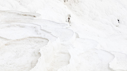 White Travertine.  The view across a white travertine terrace in Pamukkale, southwestern Turkey.  The site is a UNESCO World Heritage Site. - obrazy, fototapety, plakaty