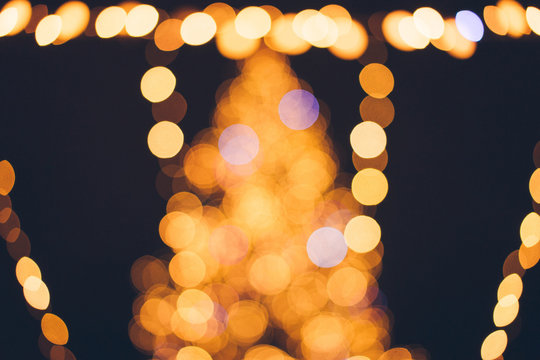 Christmas tree with colorful bokeh and Christmas lights. Blurred winter ornaments. Defocused New Year decorations.