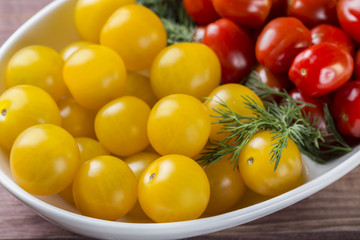 Bunch of red and yellow cherry tomatoes in a bowl