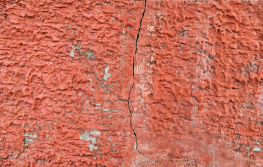 Red, plastered walls with cracks and irregularities