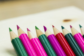 Group of sharp colored pencils with wooden background