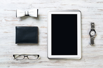 Gentleman kit of tablet watch glasses bow tie and notebook on wooden table