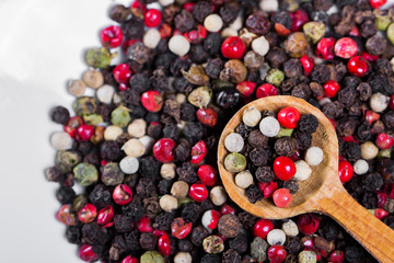 Spices closeup. A mixture of peppers in a wooden spoon.