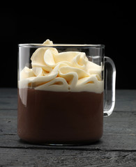 Hot chocolate cocoa with whipped cream on vintage wooden background, selective focus