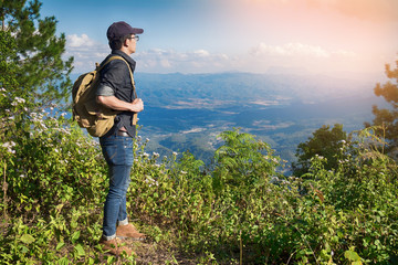 Young Man Traveler with backpack relaxing outdoor with rocky mou