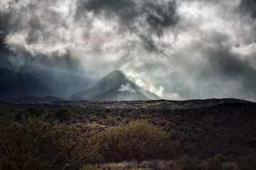 Obraz na płótnie Canvas Mountain peak with dramatic clouds and fog