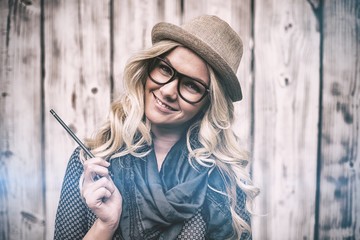 Smiling trendy blonde holding pencil