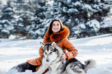 Fototapeta premium Girl playing with a dog in the park in winter.
