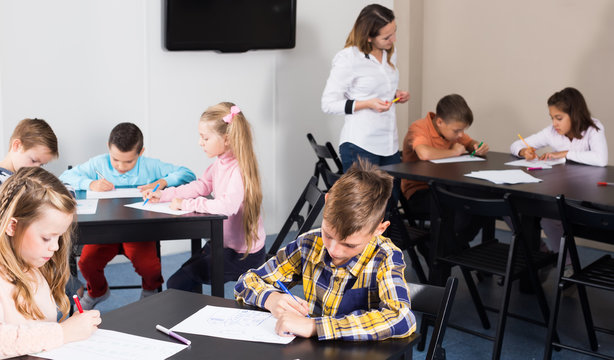 Elementary age children drawing at class in school