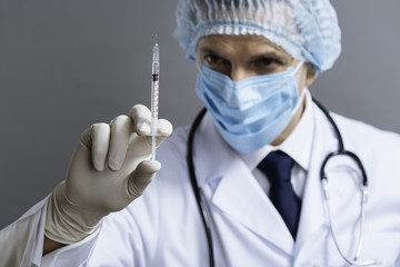 Delighted doctor holding hypodermic needle