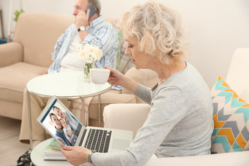 Obraz premium Video call and chat concept. Senior woman video conferencing on laptop