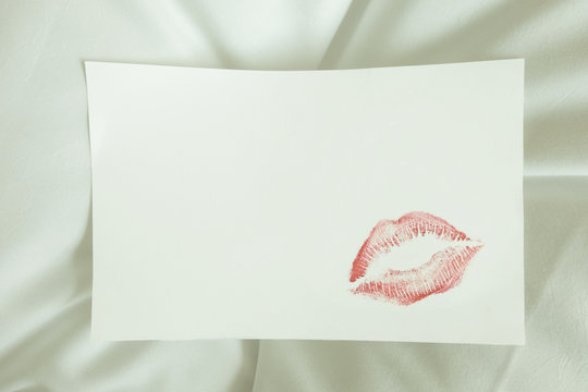 sexy red lipstick kiss on blank white note on white bed pillow sheet in the morning on valentine's day.