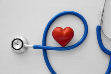 Stethoscope and red heart on table