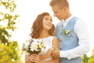 Portrait of beautiful wedding couple with bouquet of flowers
