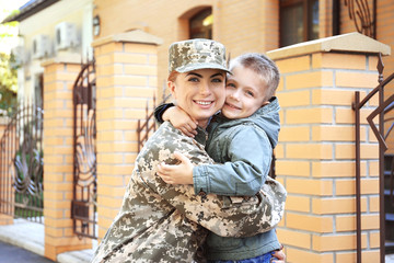Mother soldier and kid embracing at street