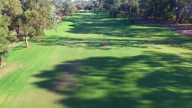 Drone aerial view of Golfers in Electric Golf Buggy with Caddy driving through Golf Course.
