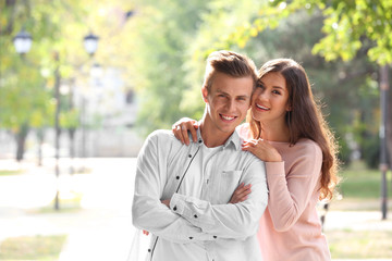 Fototapeta premium Beautiful young couple outdoors on blurred background