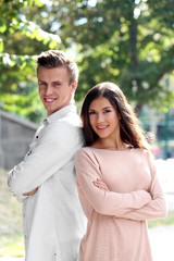 Fototapeta premium Beautiful young couple outdoors on blurred background
