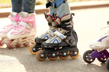 Fototapeta na wymiar Children on roller skates in park, closeup
