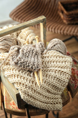 Obraz premium Wooden box with knitting handicraft on table, closeup