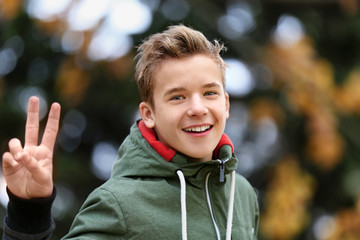 Portrait of cheerful teenager outdoors on blurred background