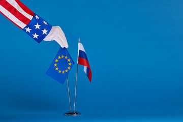 Fototapeta premium Two flags and hand on a blue background, the political concept