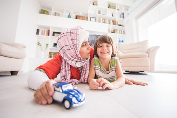Naklejka premium Mother and cute son playing with car toy at living room