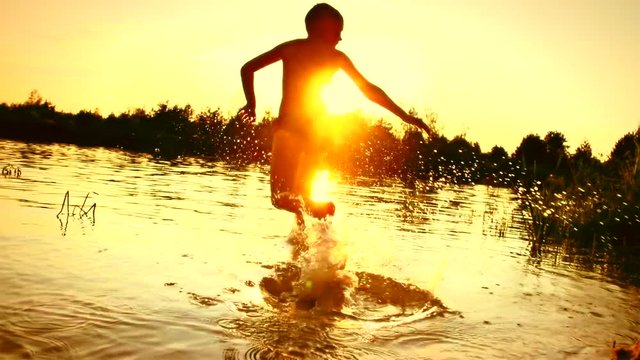 Kid having fun in water outdoors. Happy Child joyful little boy playing in River Water. Summer holidays. Summertime fun. Slow motion video footage 1080p. 240 fps