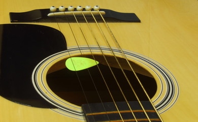 Detail low angle shot of Guitar sound hole and pegs.
