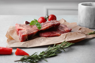 Raw steak with spices on table