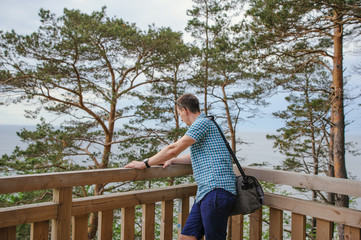Fototapeta premium man sitting on the wooden stairs in park and smiling