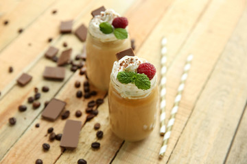Tasty milk shake cocktails with coffee beans and chocolate on wooden table
