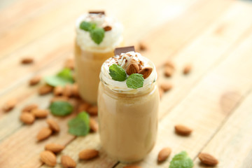 Tasty milk shake cocktails with almond nuts on wooden table